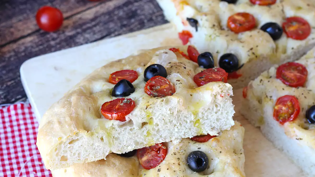 Deze dikke focaccia met cherrytomaatjes en olijven weet je al bij de eerste geur te verleiden: het recept dat je zeker moet proberen