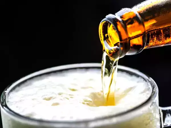Waarom schuimt bier minder als je het glas schuin houdt?