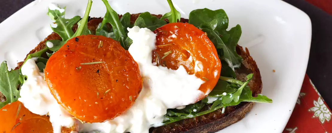 Geroosterde abrikozen, rucola en burrata op toast