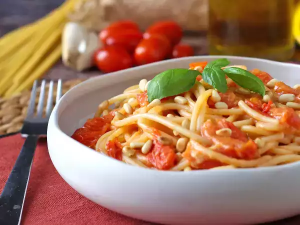 Recept Spaghetti met kerstomaatjes en pijnboompitten: een romig en geurig recept