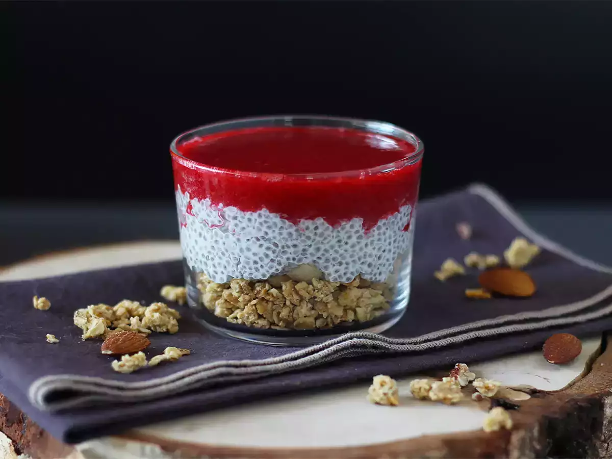 Chiazaadpudding met kokosmelk, frambozen en granola in glaasjes