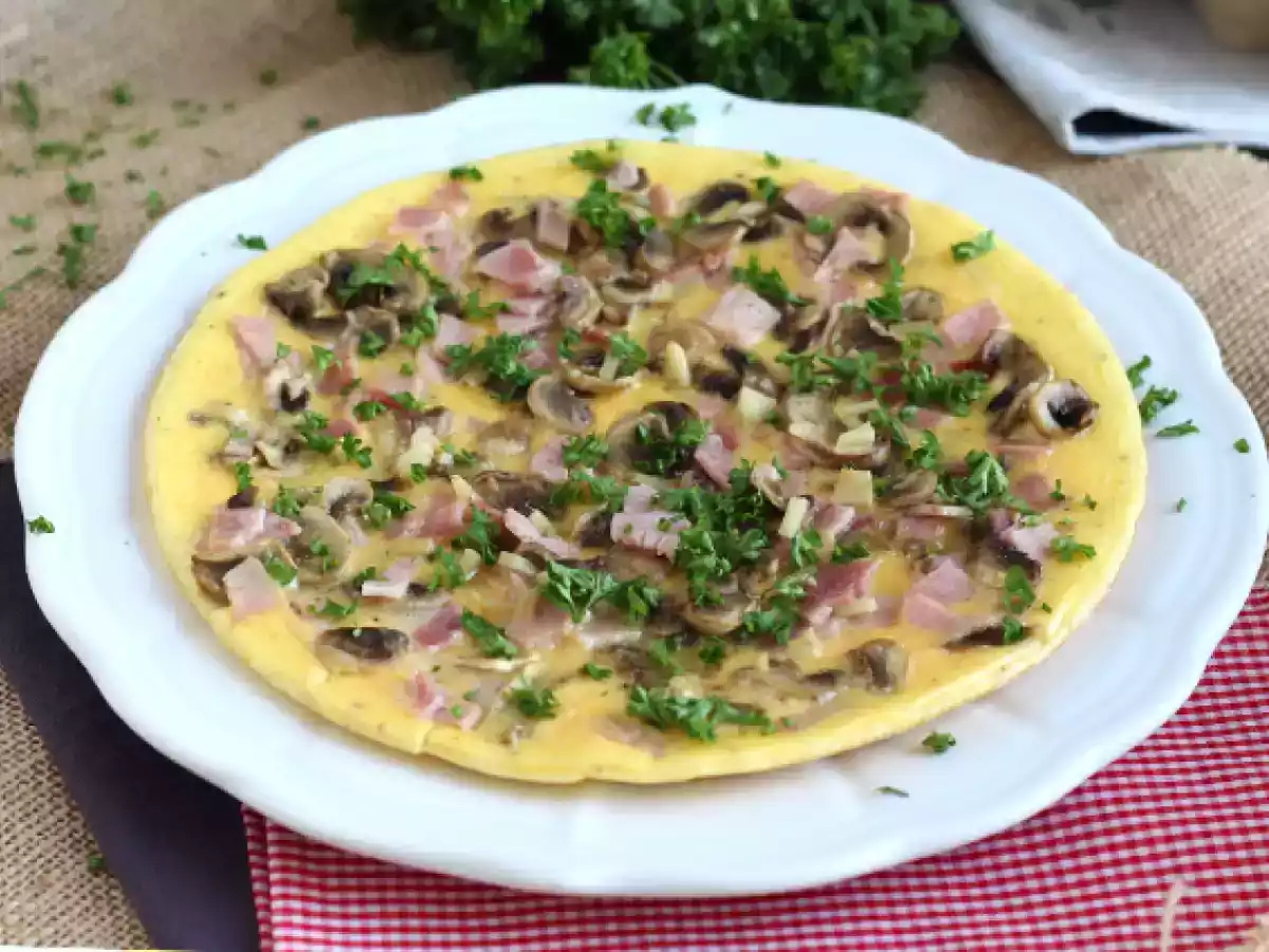 Eenvoudige omelet met champignons, ham en peterselie