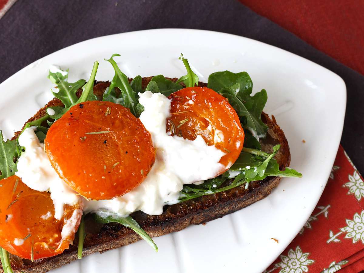 Geroosterde abrikozen, rucola en burrata op toast