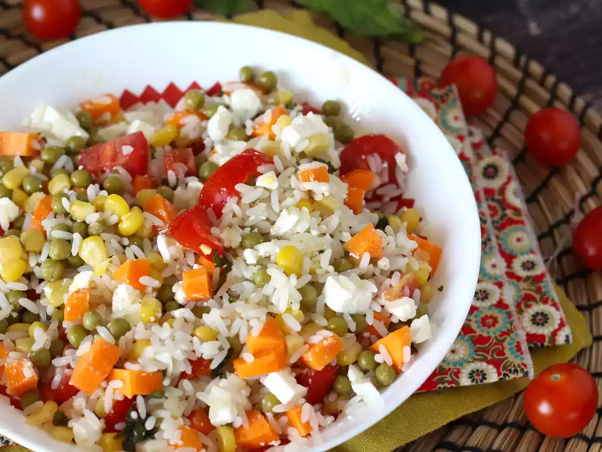 Vegetarische rijstsalade: feta, maïs, wortelen, erwten, kerstomaatjes en munt
